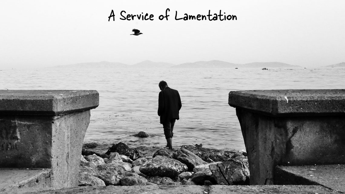 A man standing pensively by a lake