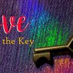 A key on a piece of clothe with multiple colors and the words Love is the Key