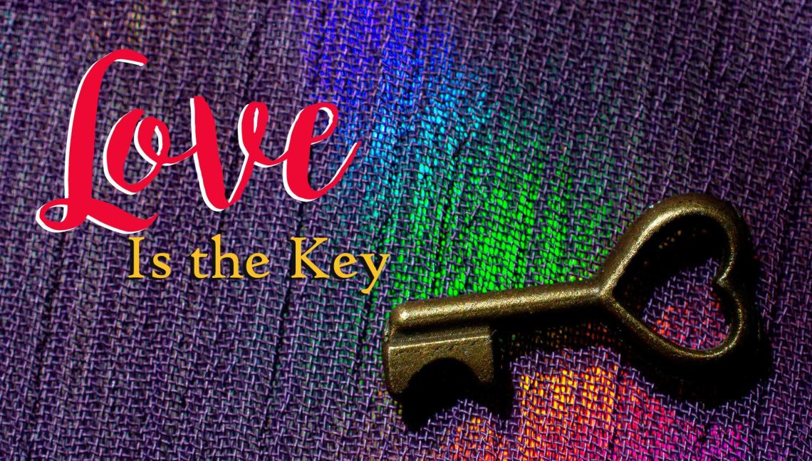 A key on a piece of clothe with multiple colors and the words Love is the Key